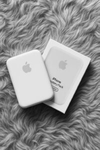Apple iPhone battery pack on soft furry surface with packaging.