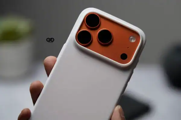 White silicone protective case with orange camera cutout for iPhone 17 Pro Max.