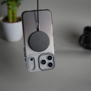 Wireless charger attached to iPhone 14 Pro with triple camera setup.